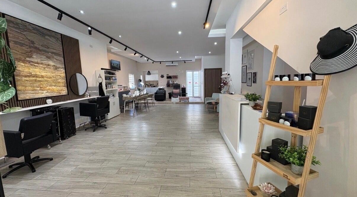 Spacious interior of Lotus Hair and Nail Salon in Il-mellieħa, MT with modern decor and styling stations.