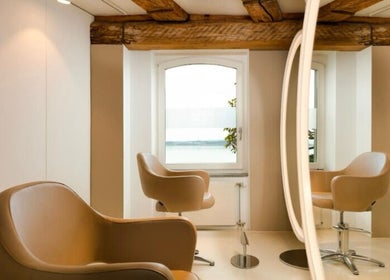 Modern salon interior at BLONDE.LAB by Caroline Rohwer — Zug, showcasing plush chairs and mirrors in Zug, Zug, CH.