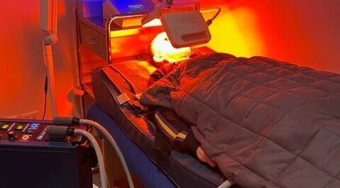 A person relaxes under a red light therapy at Biohacking Melbourne in Melbourne, Victoria, AU.