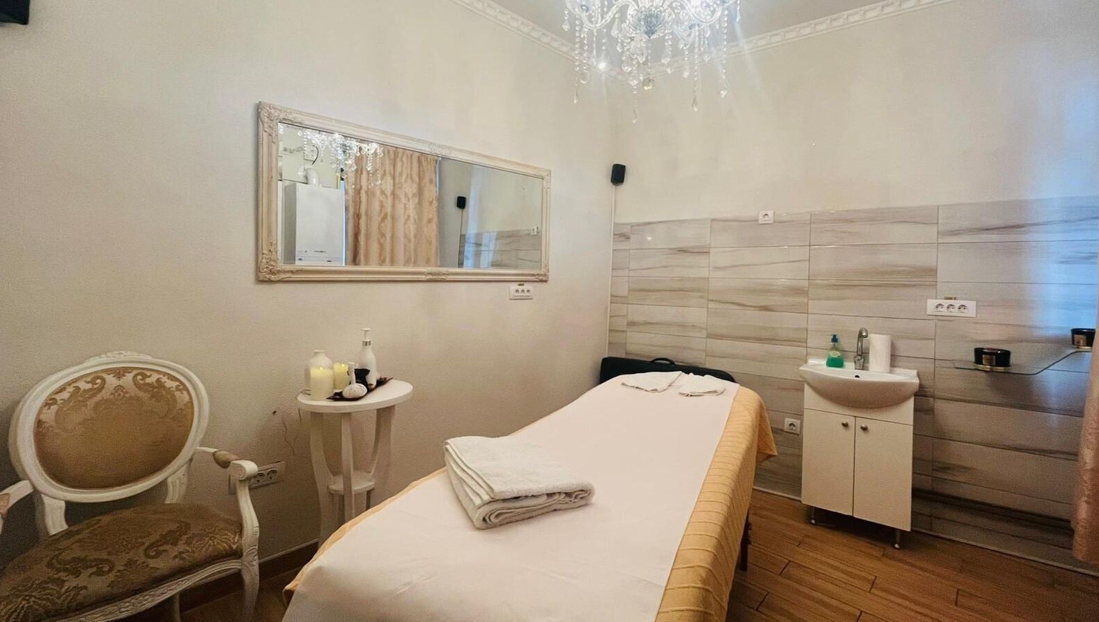 Cameră de tratament la Salon Privee, Cluj-napoca, Județul Cluj, RO, decorată elegant cu oglindă și candelabru.