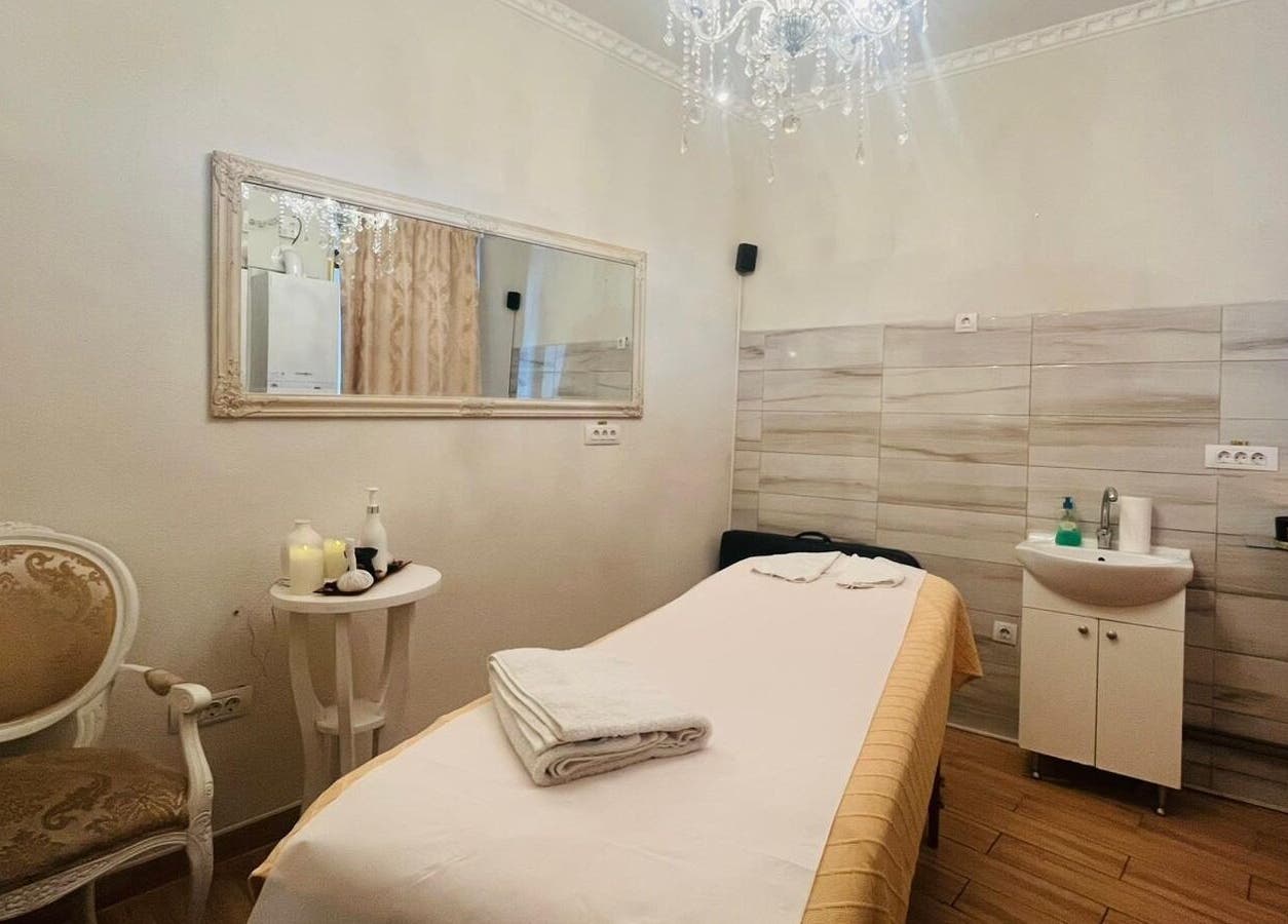 Cameră de tratament la Salon Privee, Cluj-napoca, Județul Cluj, RO, decorată elegant cu oglindă și candelabru.