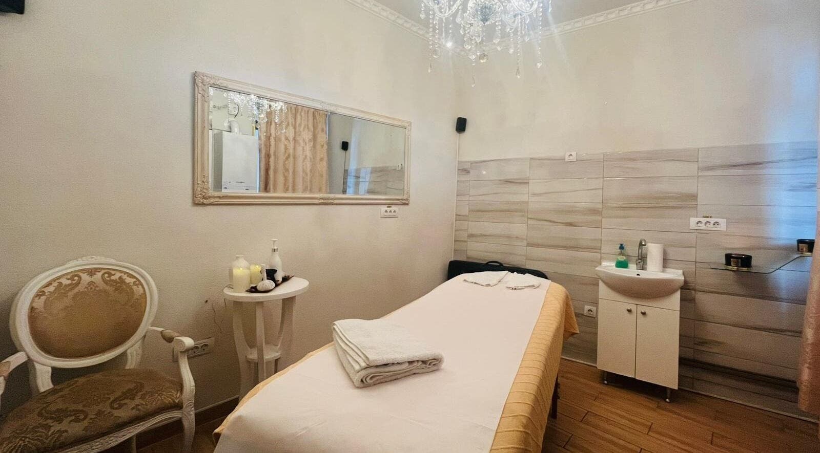 Cameră de tratament la Salon Privee, Cluj-napoca, Județul Cluj, RO, decorată elegant cu oglindă și candelabru.