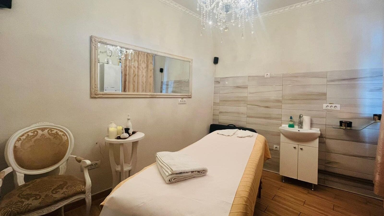 Cameră de tratament la Salon Privee, Cluj-napoca, Județul Cluj, RO, decorată elegant cu oglindă și candelabru.