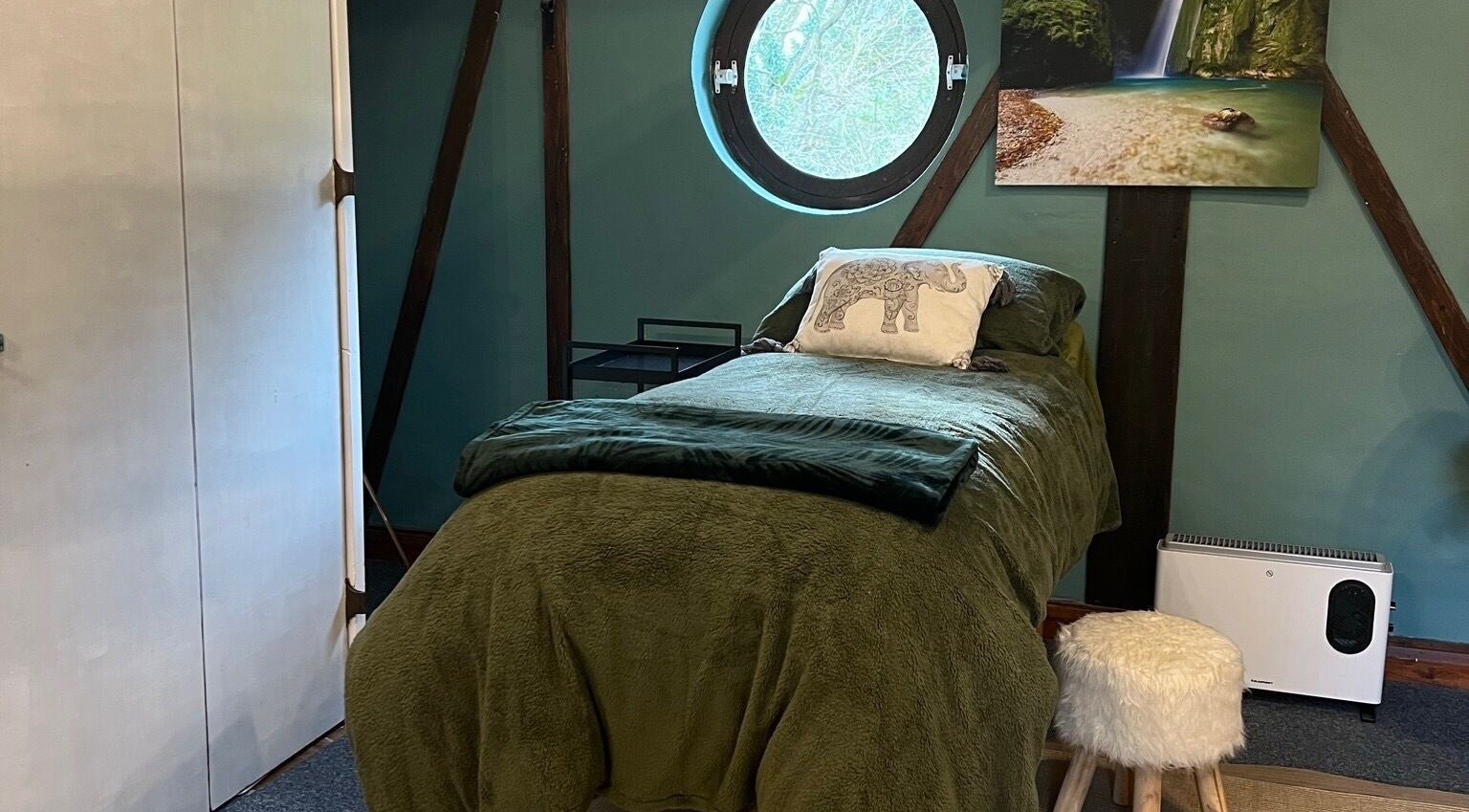 Cozy treatment room at 1 Love Holistics, Carrington, England, GB, featuring a plush bed and calming decor.