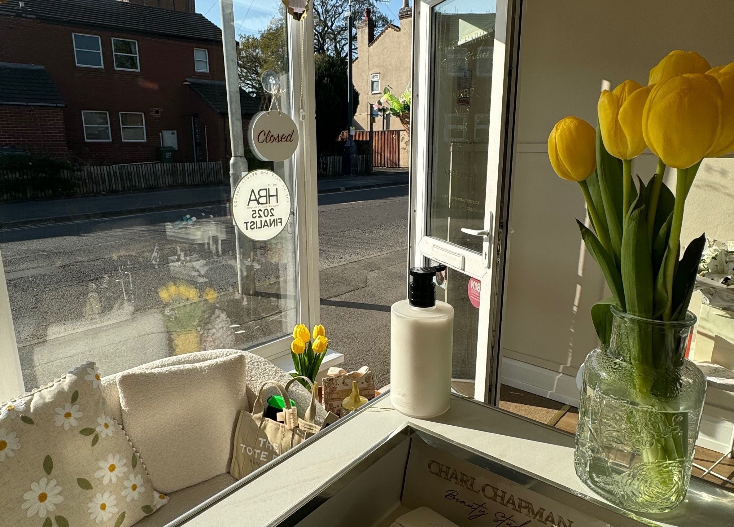 Sunlit tulips and cozy seating at Charlchapman Beauty Studios in Redditch, England, GB.