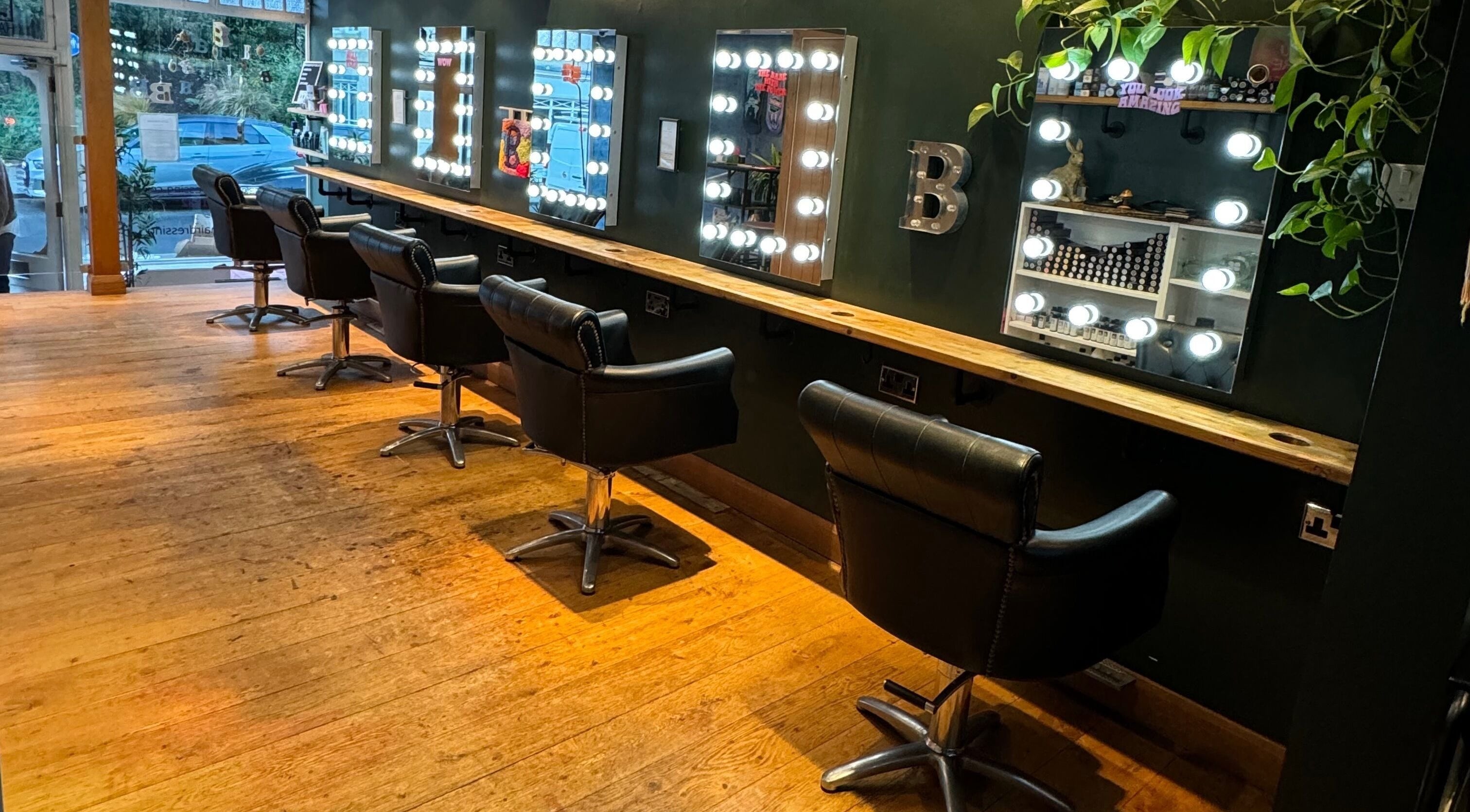 Luxurious salon chairs and lit mirrors at B Hairdressing, Bath, England, GB, ideal for a stylish makeover.