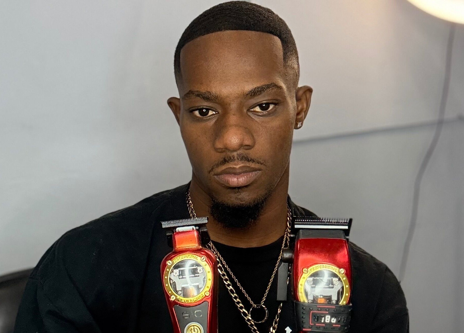 Barber with clippers at CliffCutz, St.patricks, Christ Church, BB, showcasing top-notch grooming tools.