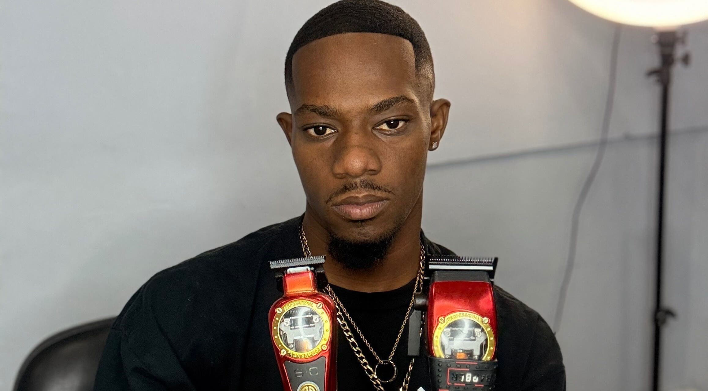 Barber with clippers at CliffCutz, St.patricks, Christ Church, BB, showcasing top-notch grooming tools.