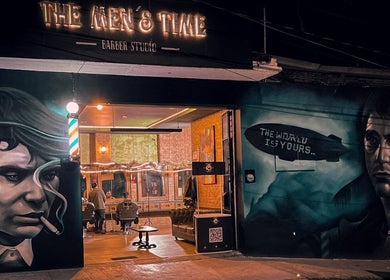 Fachada de The Men's Time en Xalapa-enríquez, Veracruz, MX, iluminada en la noche con arte urbano.