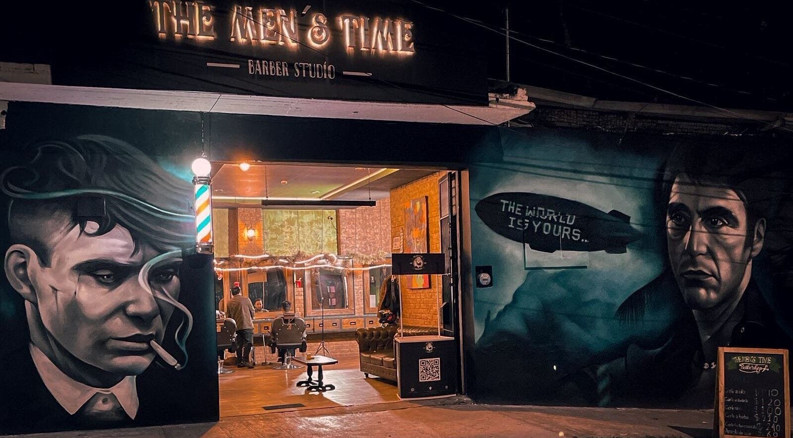 Fachada de The Men's Time en Xalapa-enríquez, Veracruz, MX, iluminada en la noche con arte urbano.