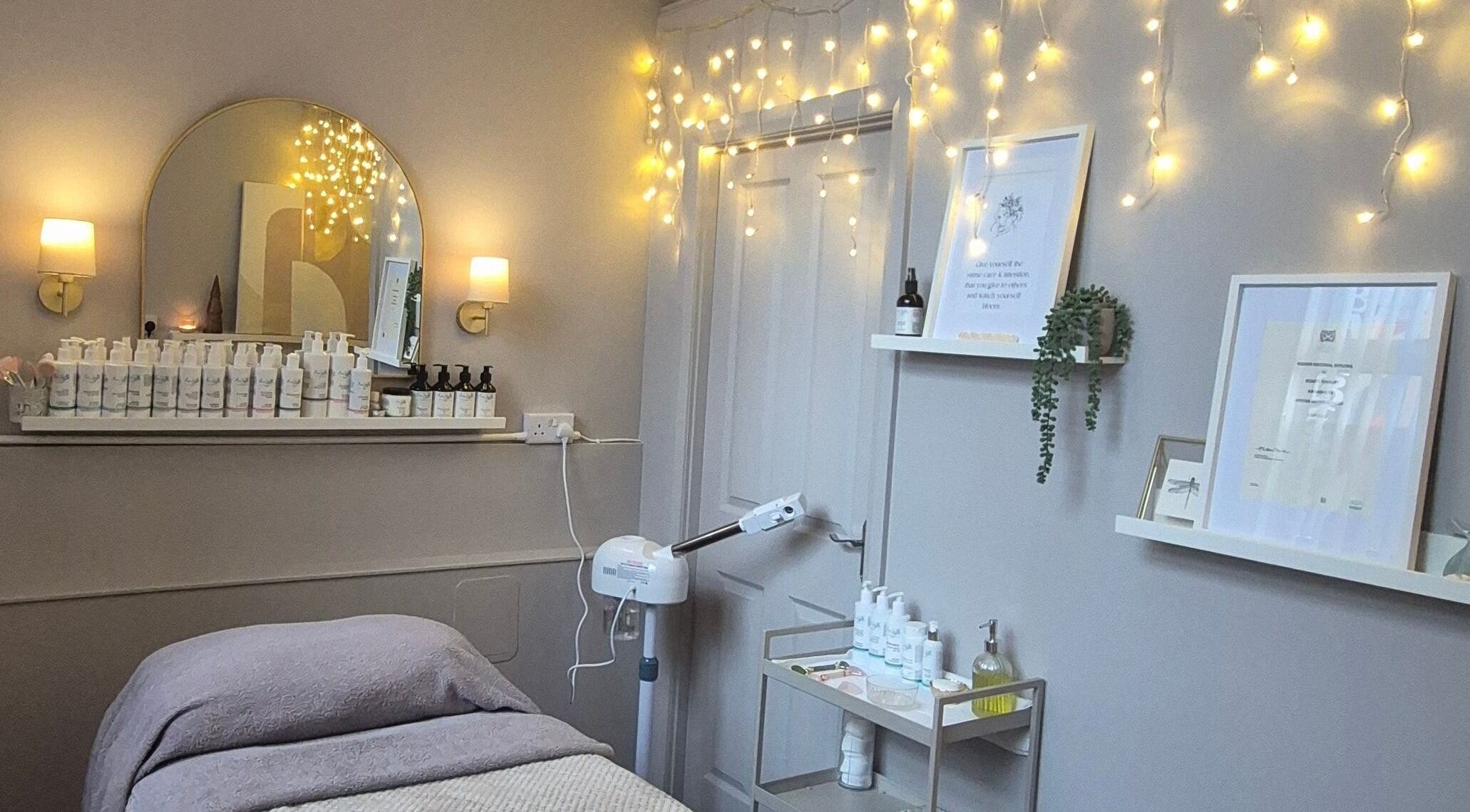 Cozy treatment room at Nirvana Beauty & Massage, Bonnybridge, Scotland, with soothing lights and skincare products.