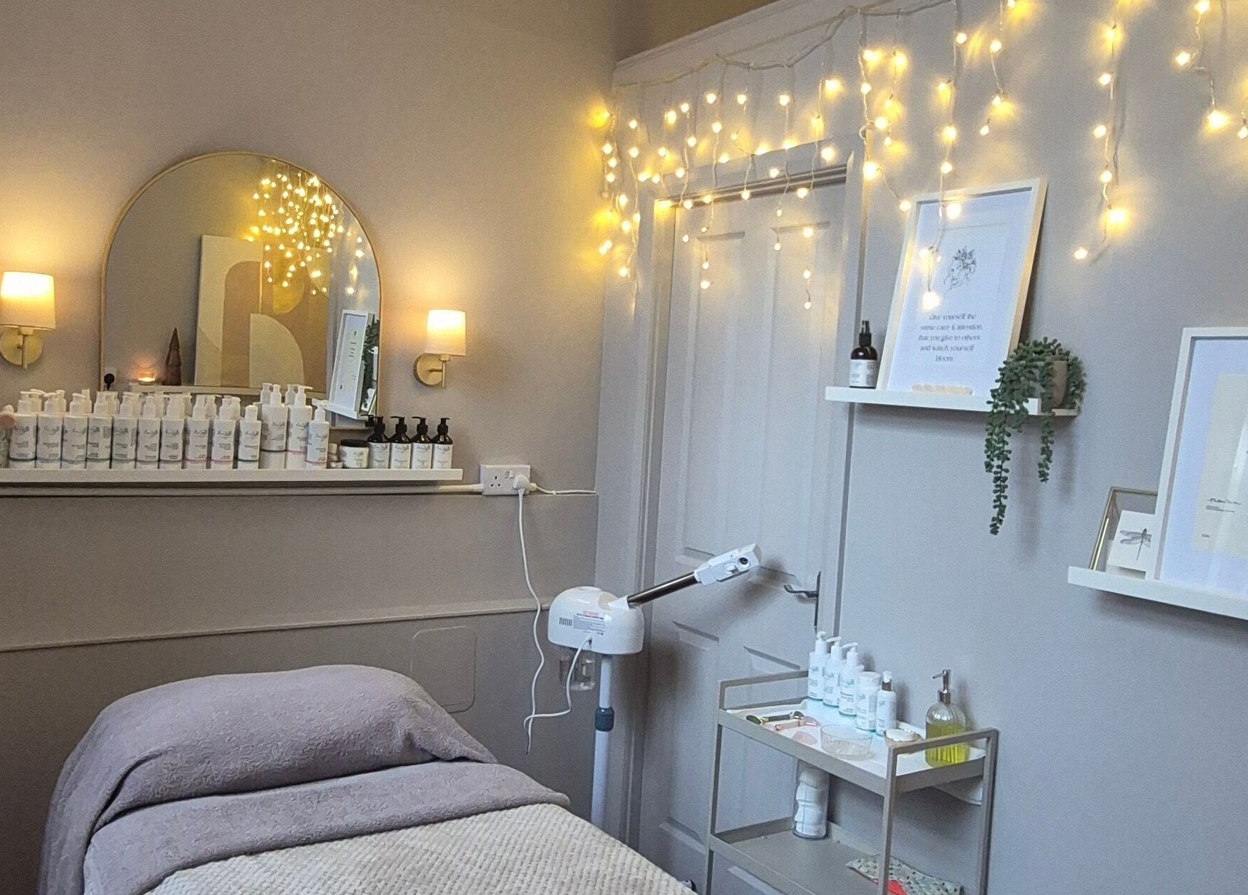 Cozy beauty treatment room at Nirvana Beauty & Massage, Bonnybridge, Scotland, GB with soft lighting, products.