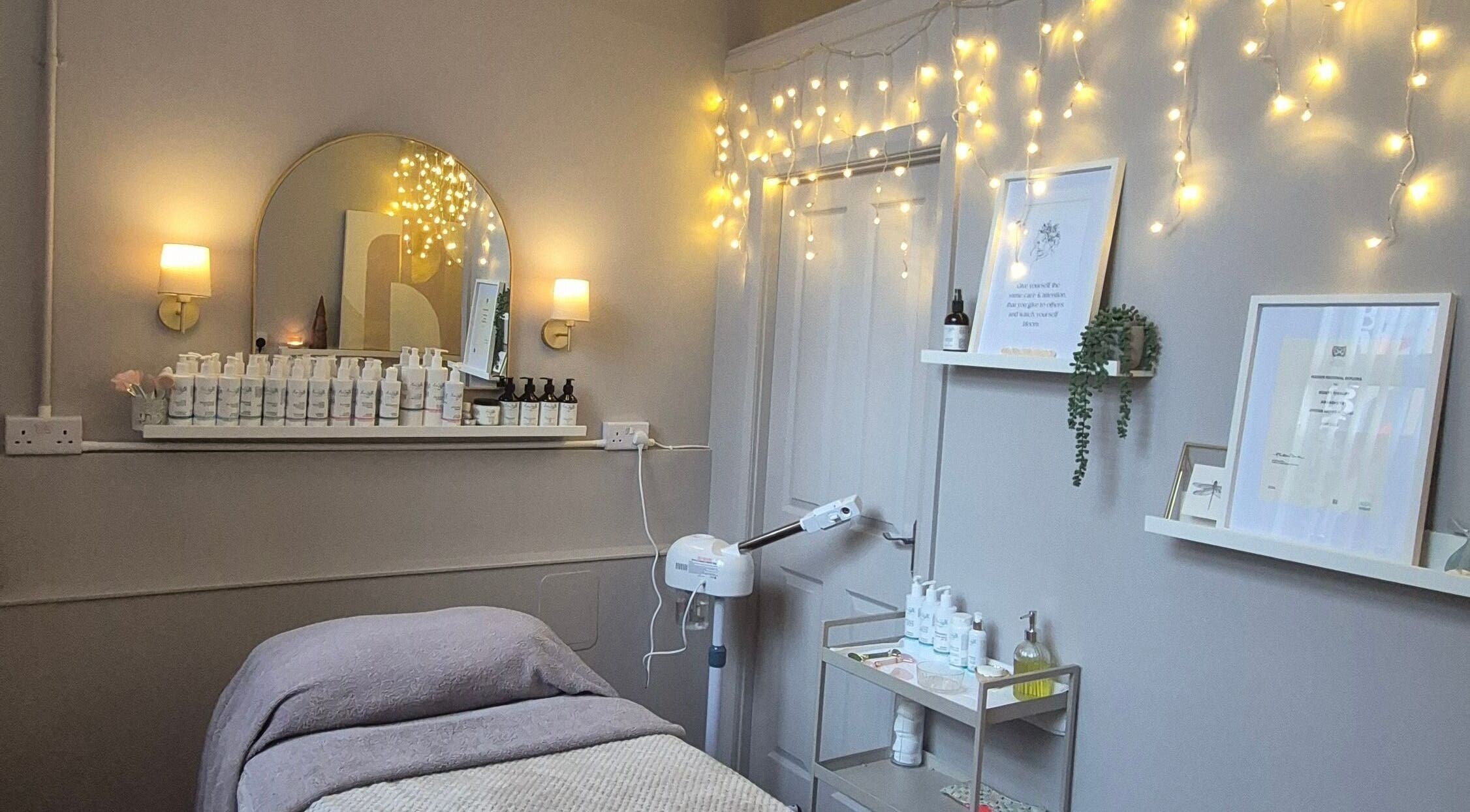 Cozy beauty treatment room at Nirvana Beauty & Massage, Bonnybridge, Scotland, GB with soft lighting, products.