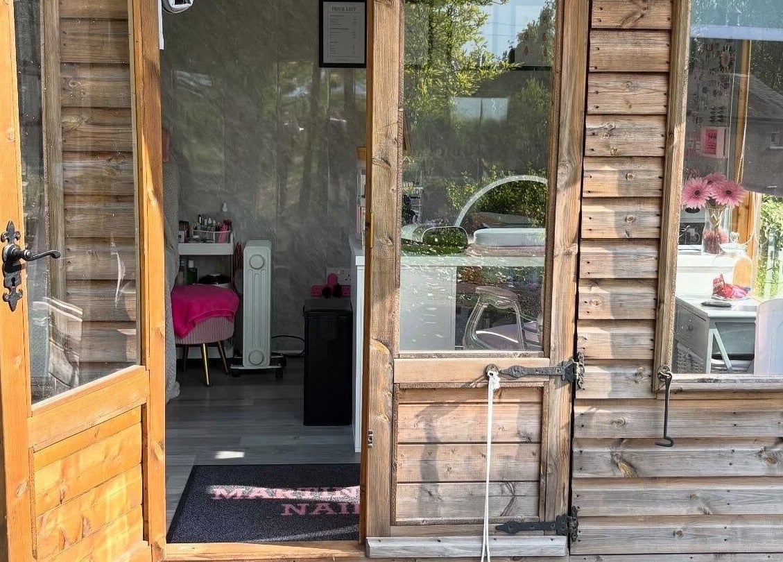 Entrance to Martindale Nails in Kendal, England, GB showcasing a rustic wooden exterior and inviting interior.