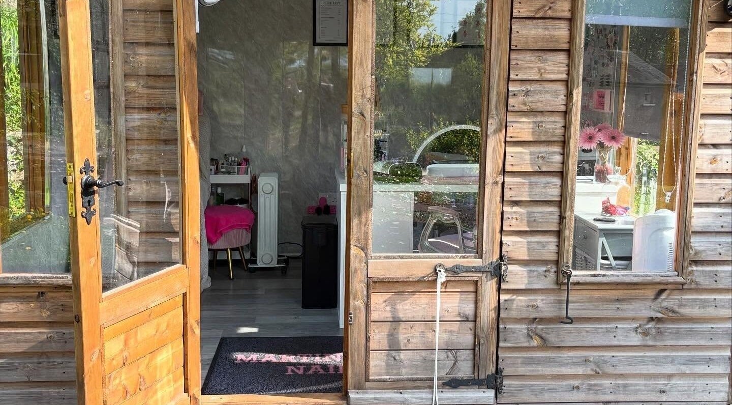 Entrance to Martindale Nails in Kendal, England, GB showcasing a rustic wooden exterior and inviting interior.