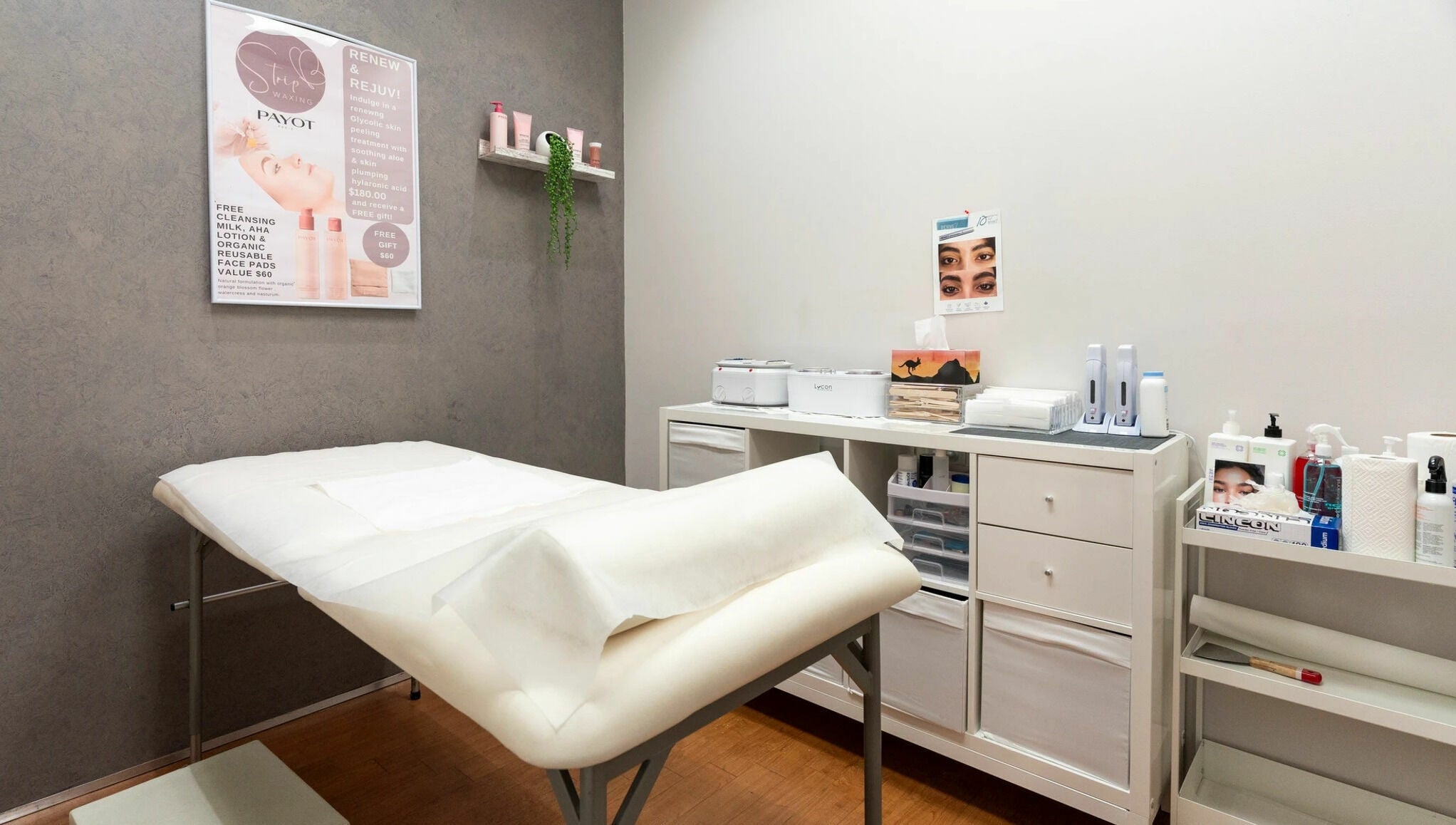 Interior of Strip Womens Waxing Clinic, Subiaco, Western Australia, AU. Cozy treatment bed and skincare products.