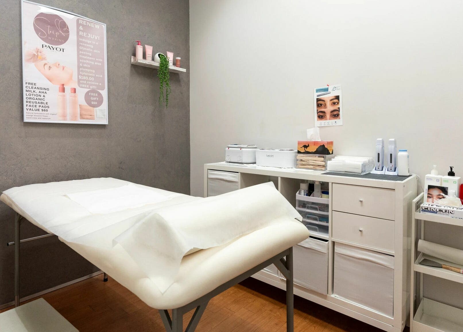Interior of Strip Womens Waxing Clinic, Subiaco, Western Australia, AU. Cozy treatment bed and skincare products.