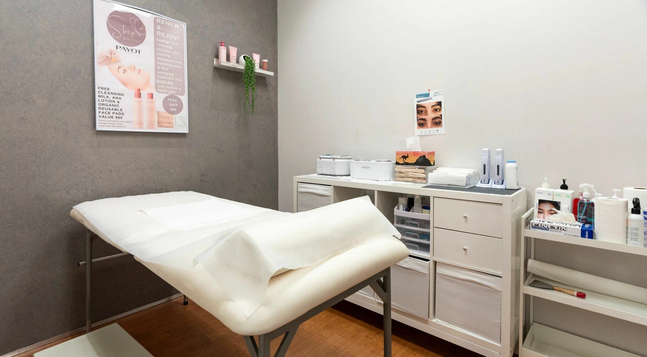 Interior of Strip Womens Waxing Clinic, Subiaco, Western Australia, AU. Cozy treatment bed and skincare products.