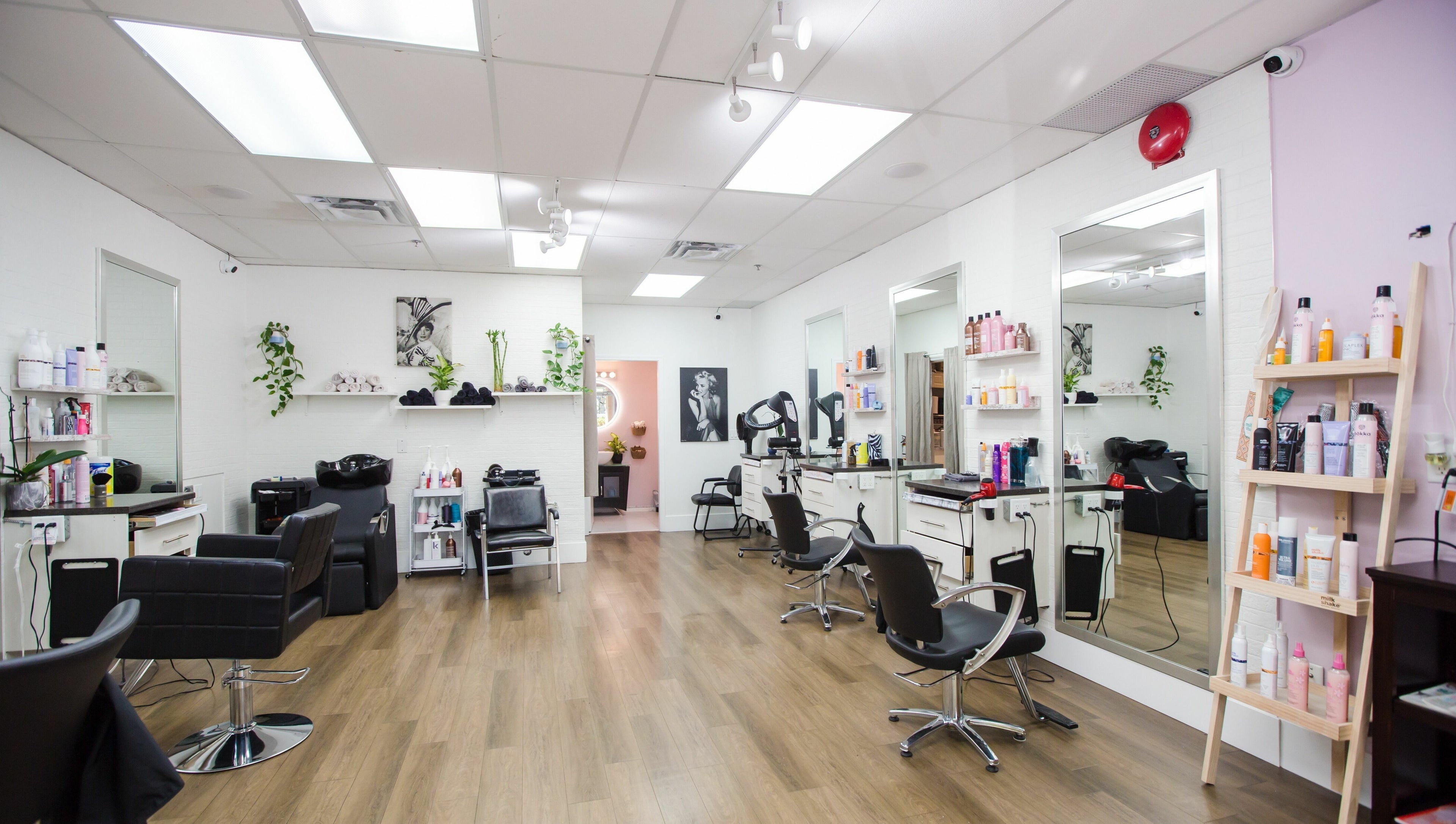Interior of JPL Hair Studio in Langley, BC, CA showcasing modern chairs, mirrors, and styling products.