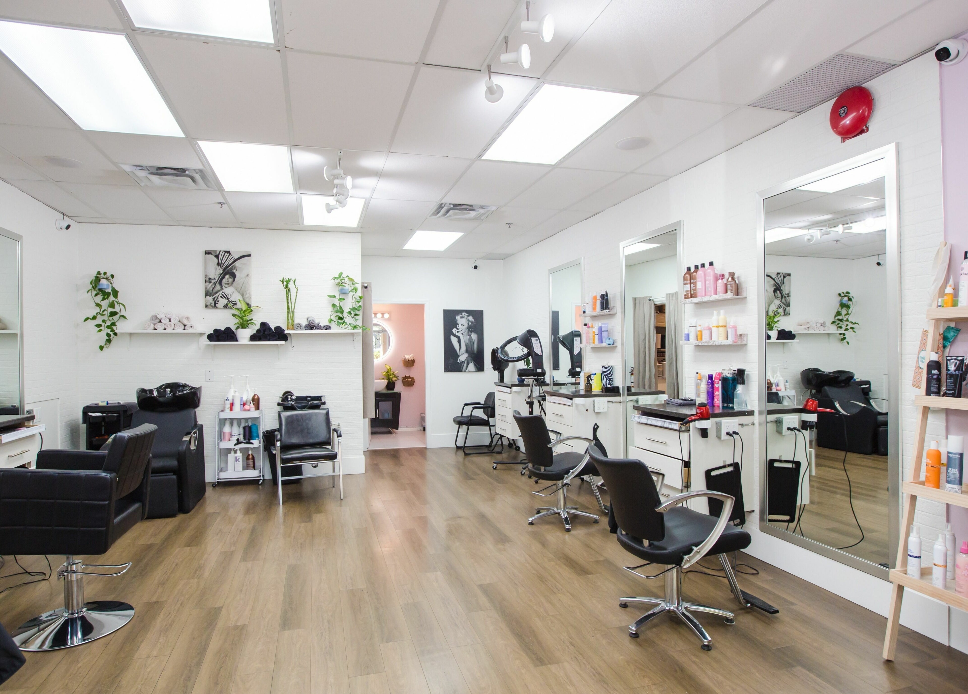 Interior of JPL Hair Studio in Langley, BC, CA showcasing modern chairs, mirrors, and styling products.