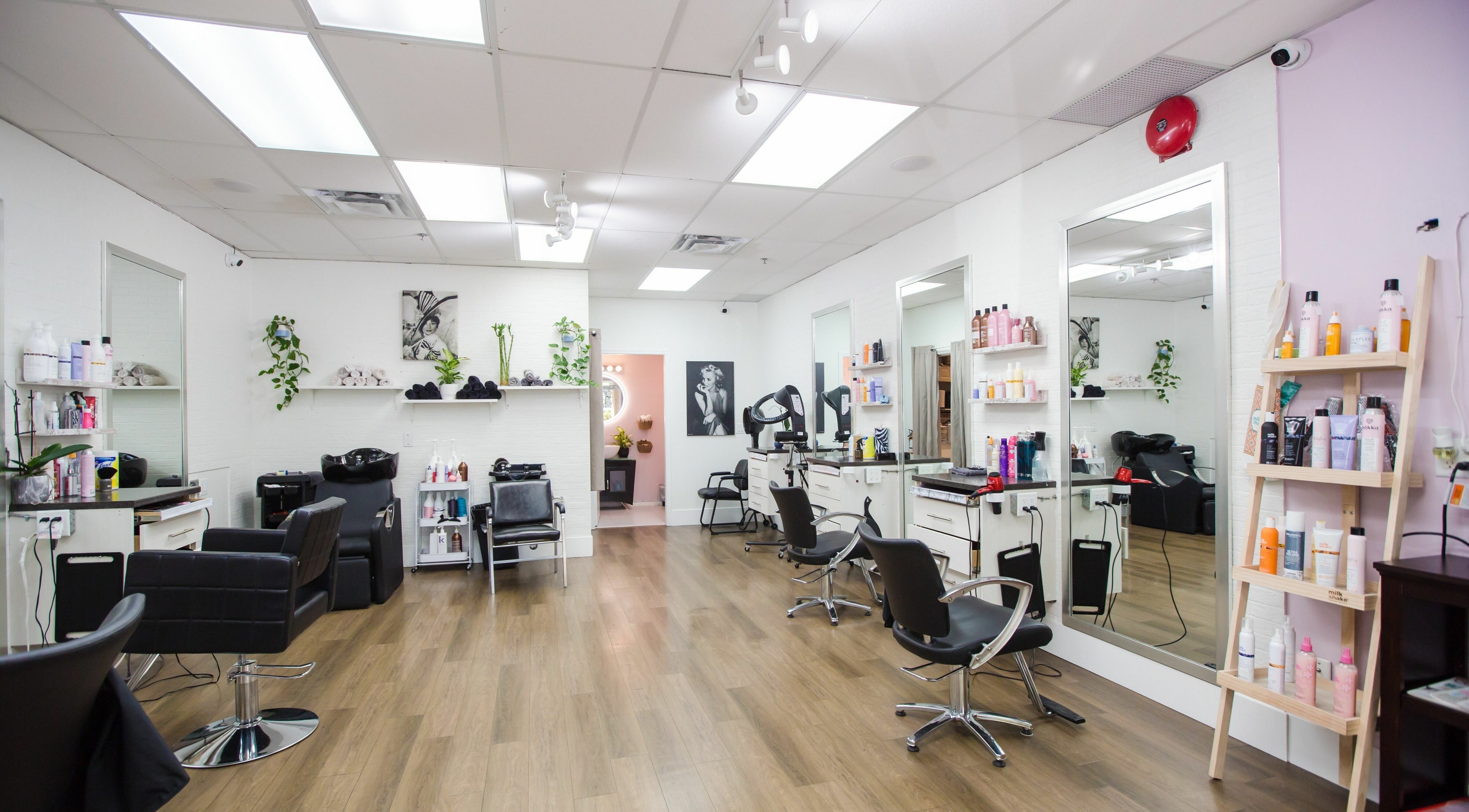 Interior of JPL Hair Studio in Langley, BC, CA showcasing modern chairs, mirrors, and styling products.