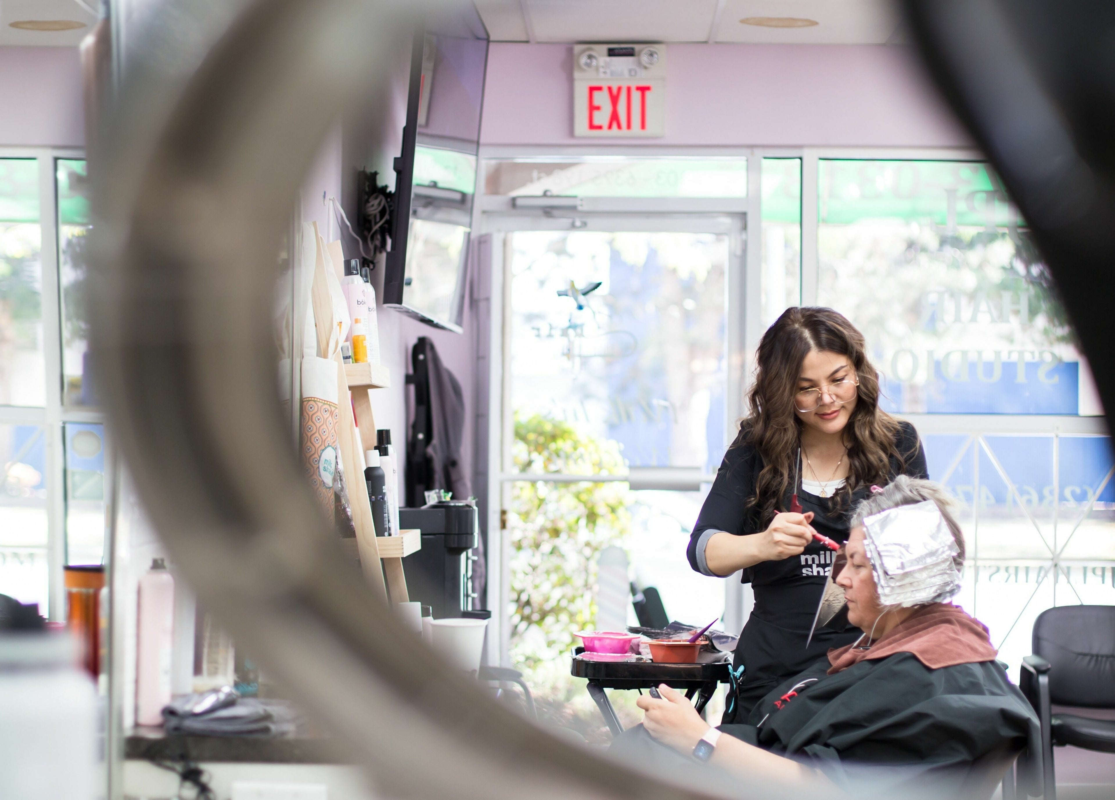 Stylist at JPL Hair Studio in Langley, British Columbia, CA, applying hair color to a client.
