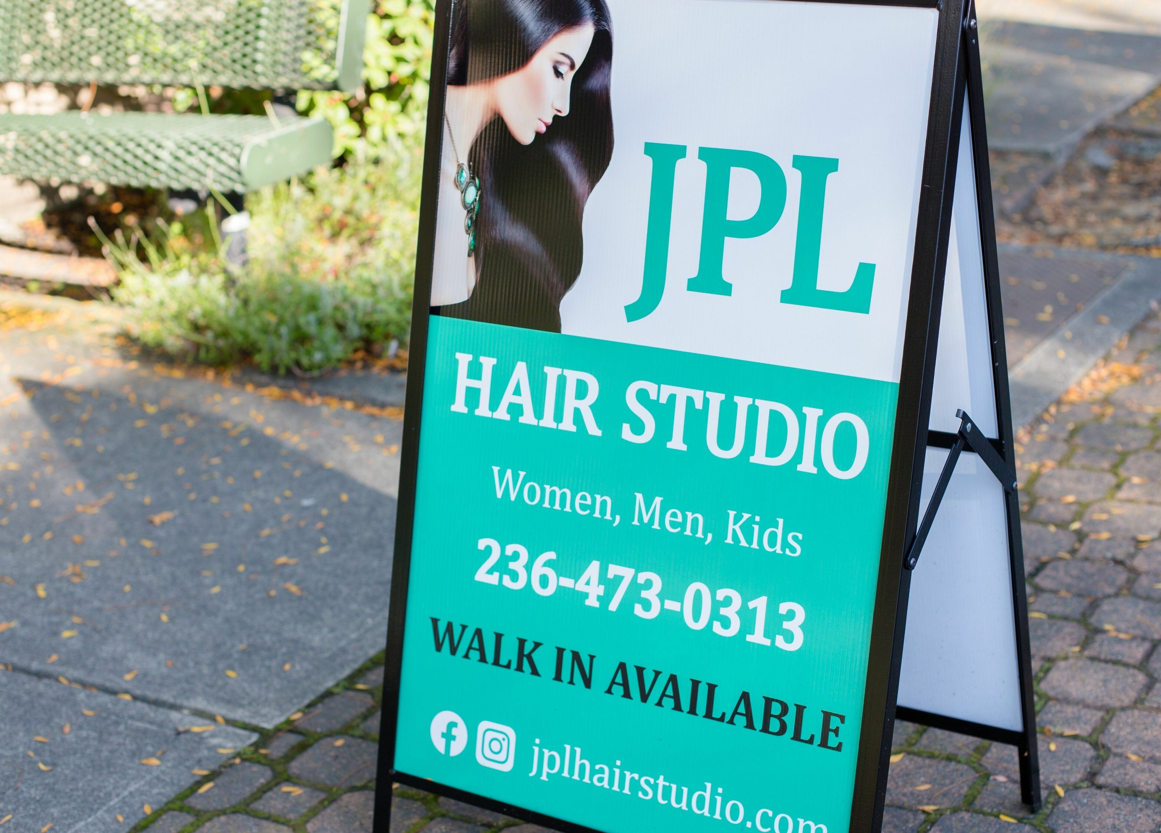 A-frame sign for JPL Hair Studio in Langley, British Columbia, CA, displaying contact info and services for all ages.