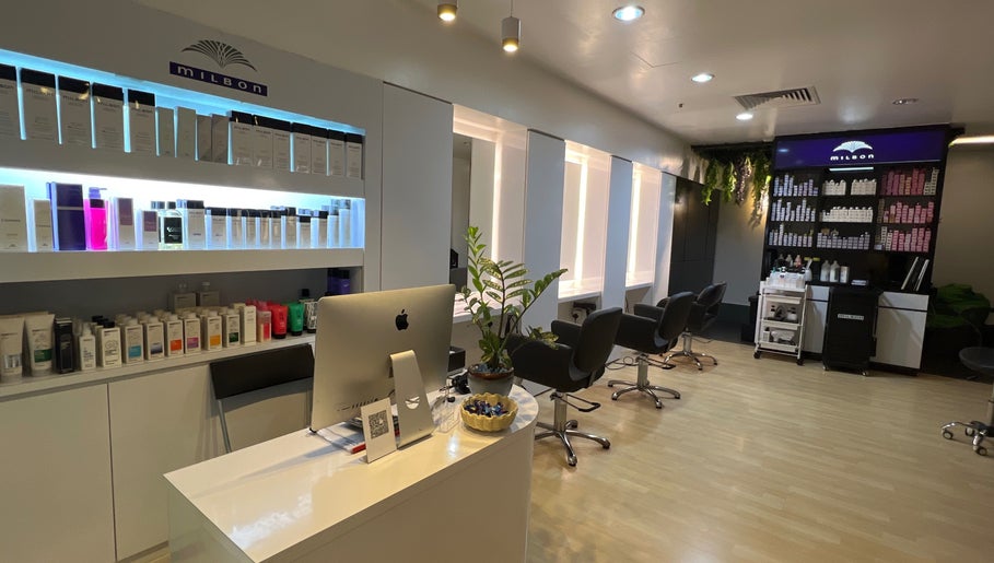 Modern salon interior at Topcurls Salon, Singapore, showcasing styling chairs and hair products.