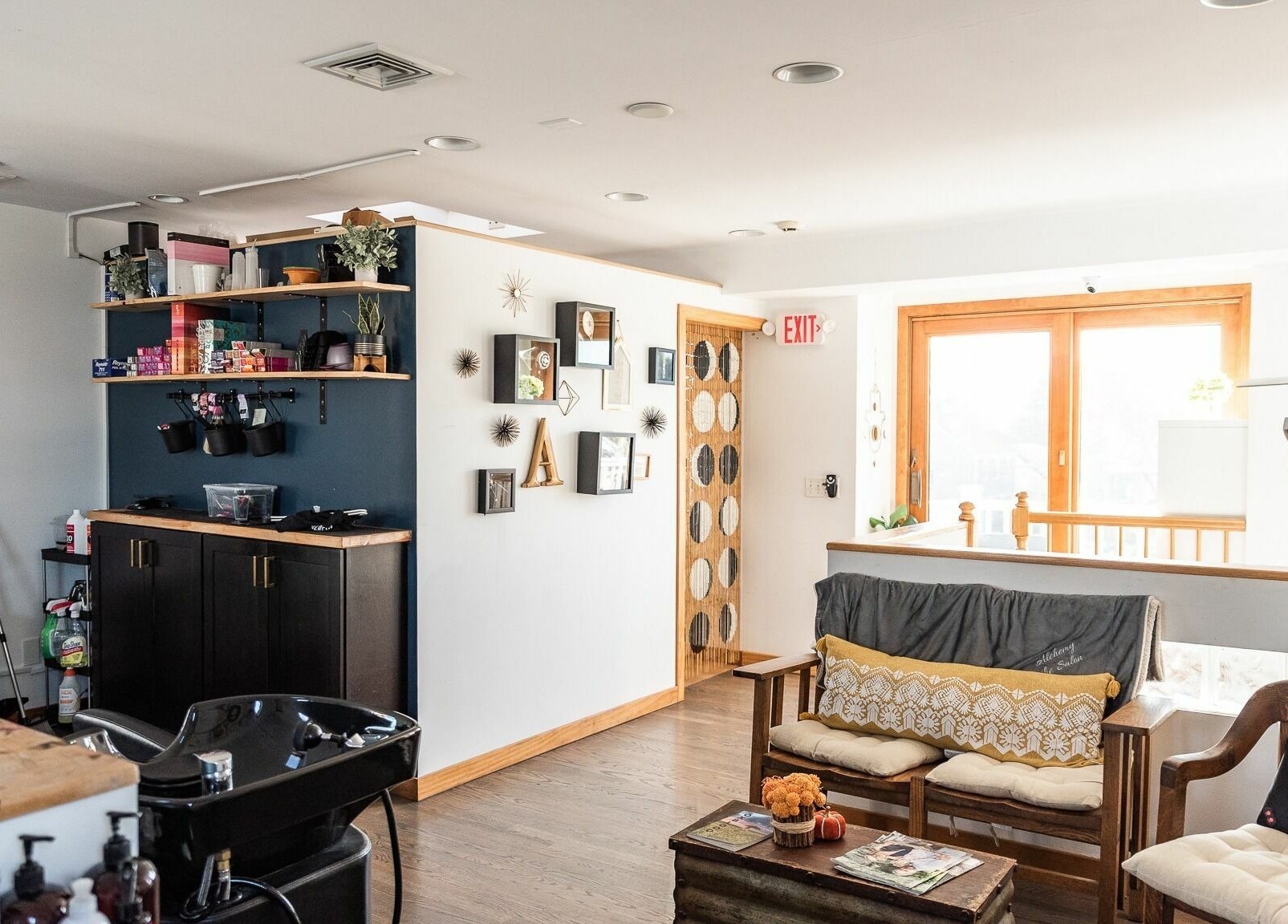 Inviting interior of Alchemy, the Salon in Fairfield, Connecticut, US, showcasing stylish seating and decor.