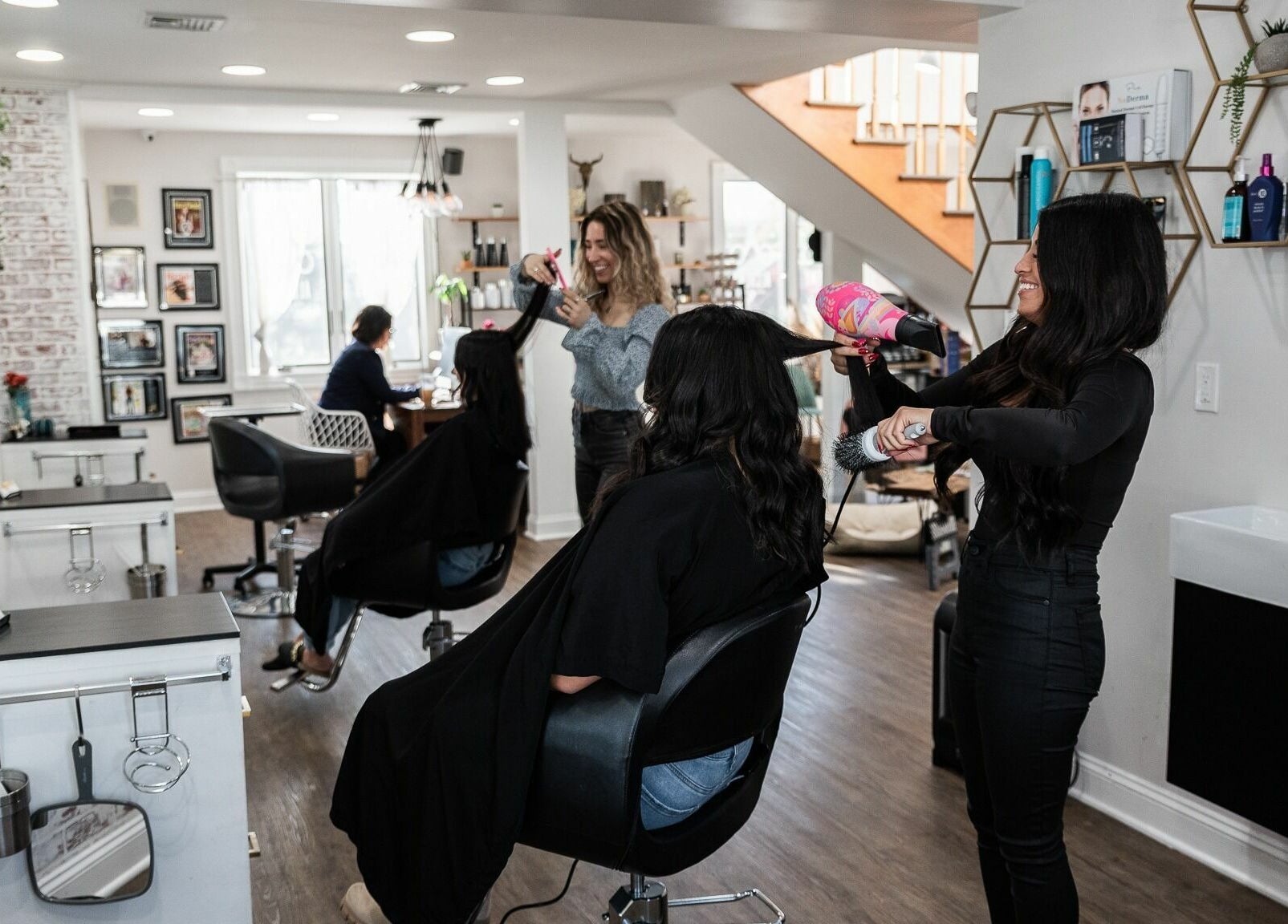 Salon professionals styling hair at Alchemy, the Salon in Fairfield, Connecticut, US. Chic and inviting atmosphere.