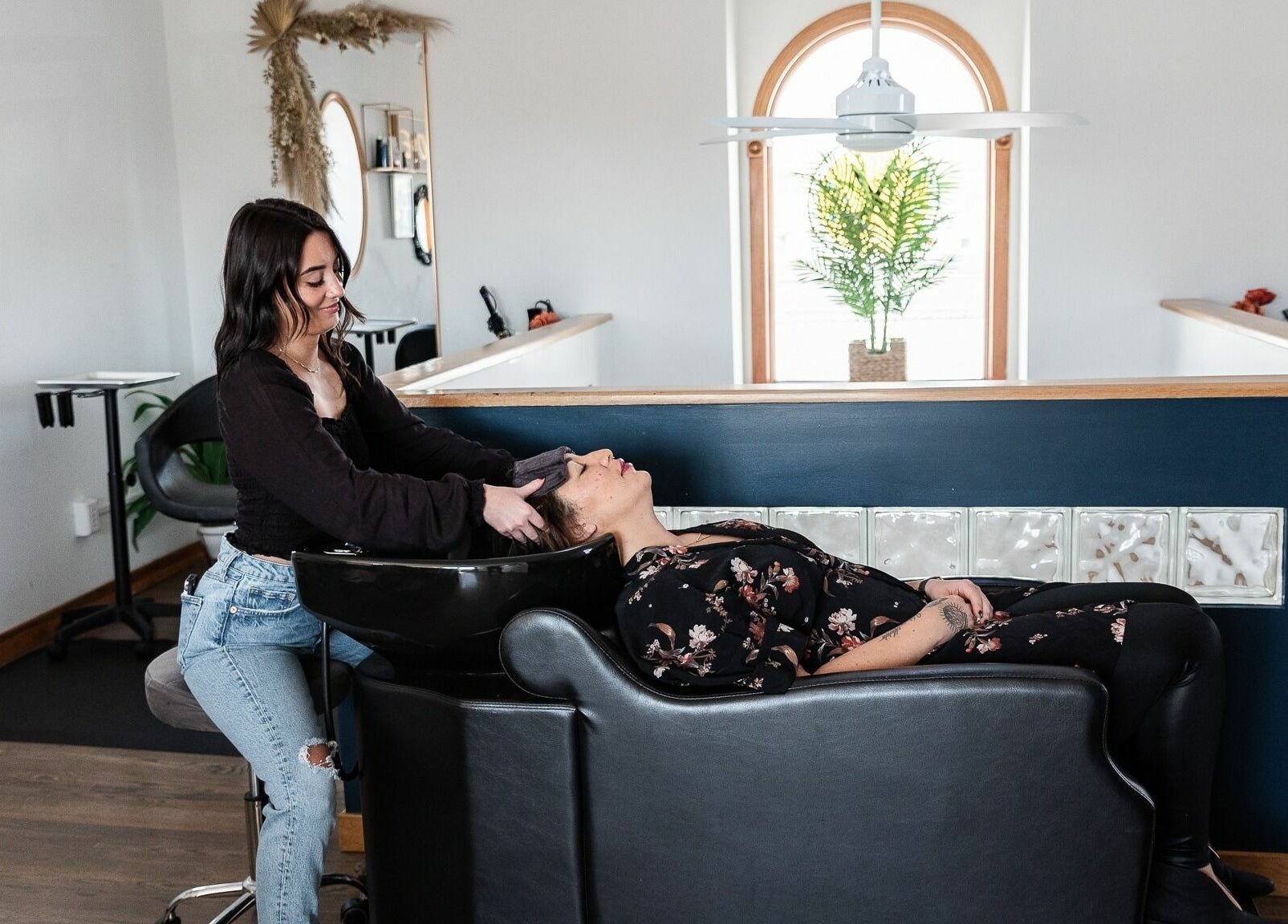 Hairdresser at Alchemy, the Salon in Fairfield, Connecticut, US, providing a relaxing hair wash in a chic setting.
