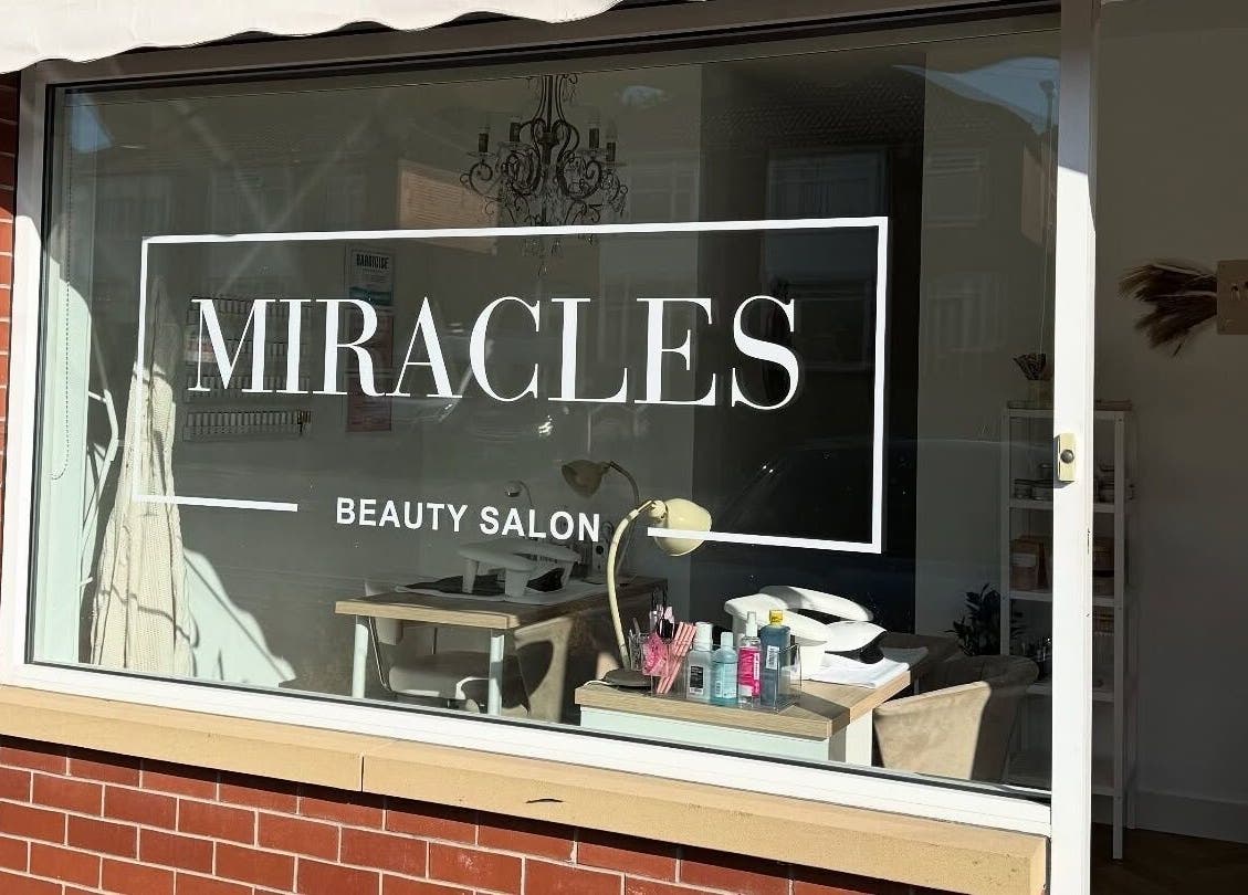 Exterior of Miracles Beauty Salon, Brighouse, England, showcasing inviting window and interior decor.