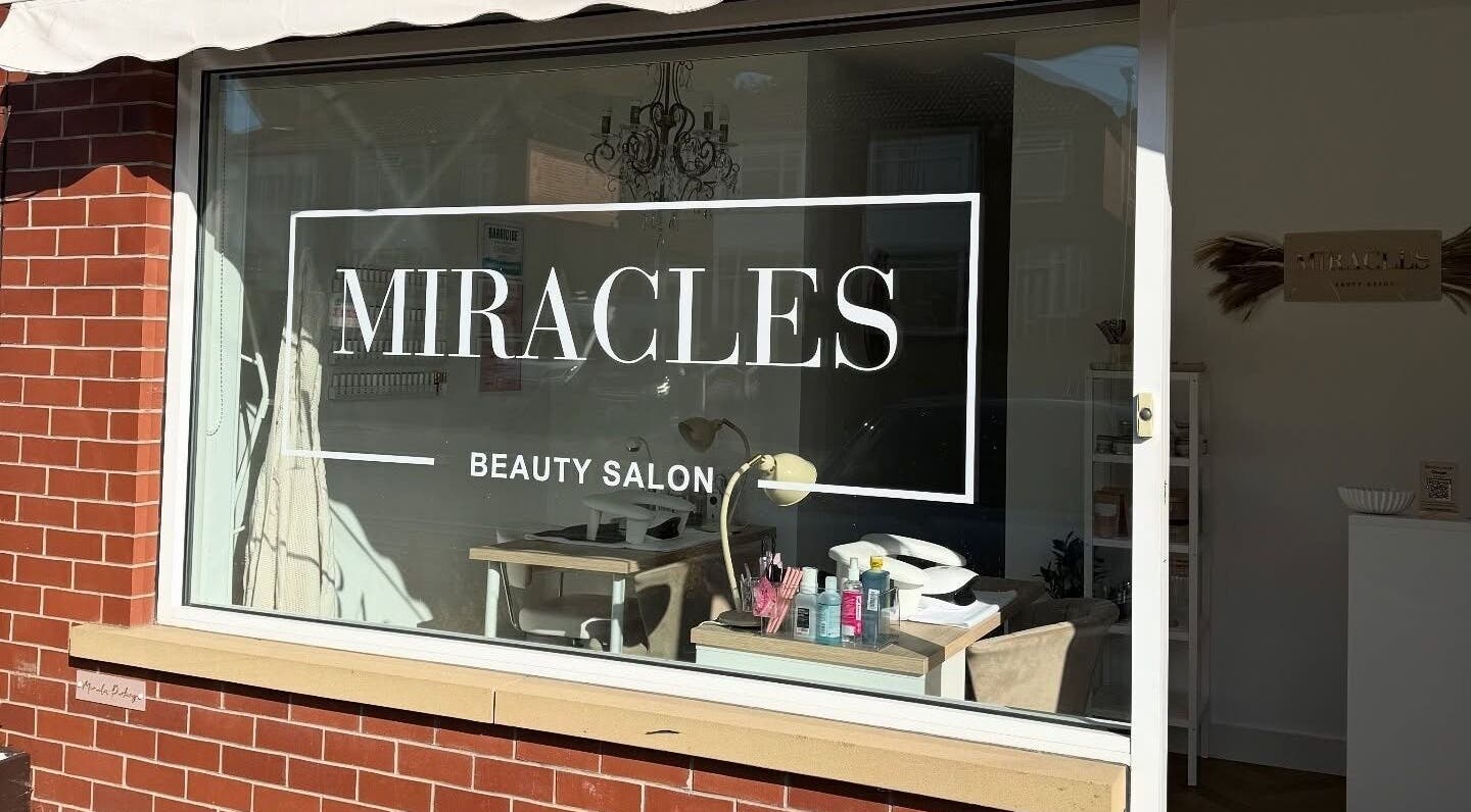 Exterior of Miracles Beauty Salon, Brighouse, England, showcasing inviting window and interior decor.