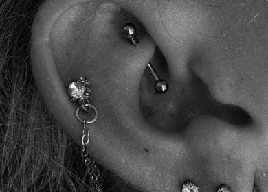 Close-up of an ear with piercings at Studio 59, Rumney, Wales, GB, showcasing elegant jewelry.