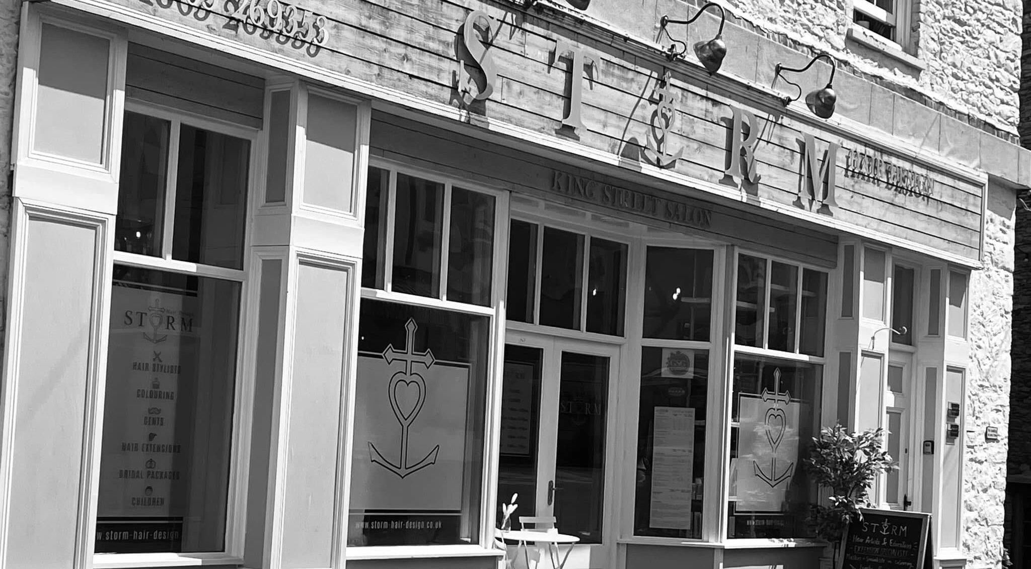 Front view of Storm Hair Design salon in Brixham, England, GB, featuring stylish signage and large windows.