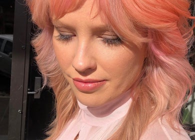 Woman with pink hair glowing in sunlight at Cass at Marina Drive, Shell Cove, New South Wales, AU.
