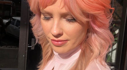 Woman with pink hair glowing in sunlight at Cass at Marina Drive, Shell Cove, New South Wales, AU.