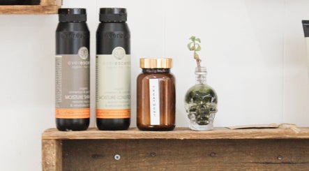 Organic hair products at Cass Indie Hair Artist in Mount Clear, Victoria, AU, showcased on a wooden shelf.