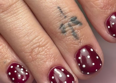 Close-up of elegant red polka-dot nails at LilyBeautyandNails in Burton-on-trent, England, GB.
