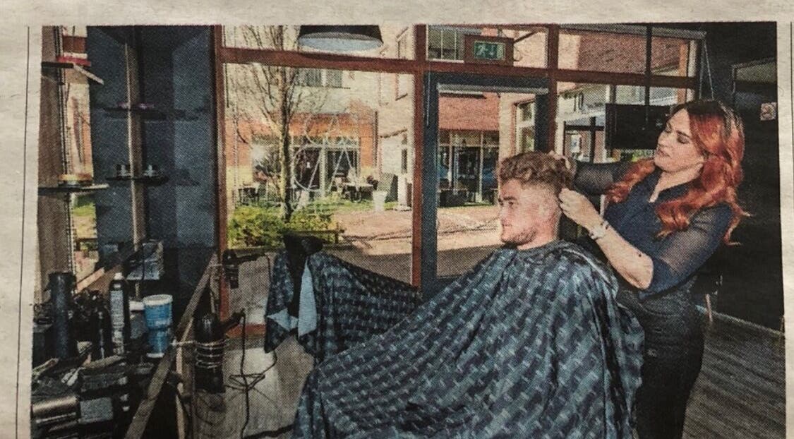 Kapper aan het werk bij V Artistry in Ravels, Vlaanderen, BE, met moderne inrichting en natuurlijk licht.