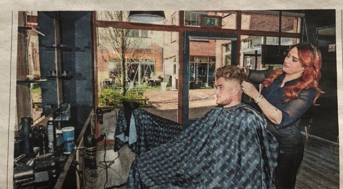 Kapper aan het werk bij V Artistry in Ravels, Vlaanderen, BE, met moderne inrichting en natuurlijk licht.