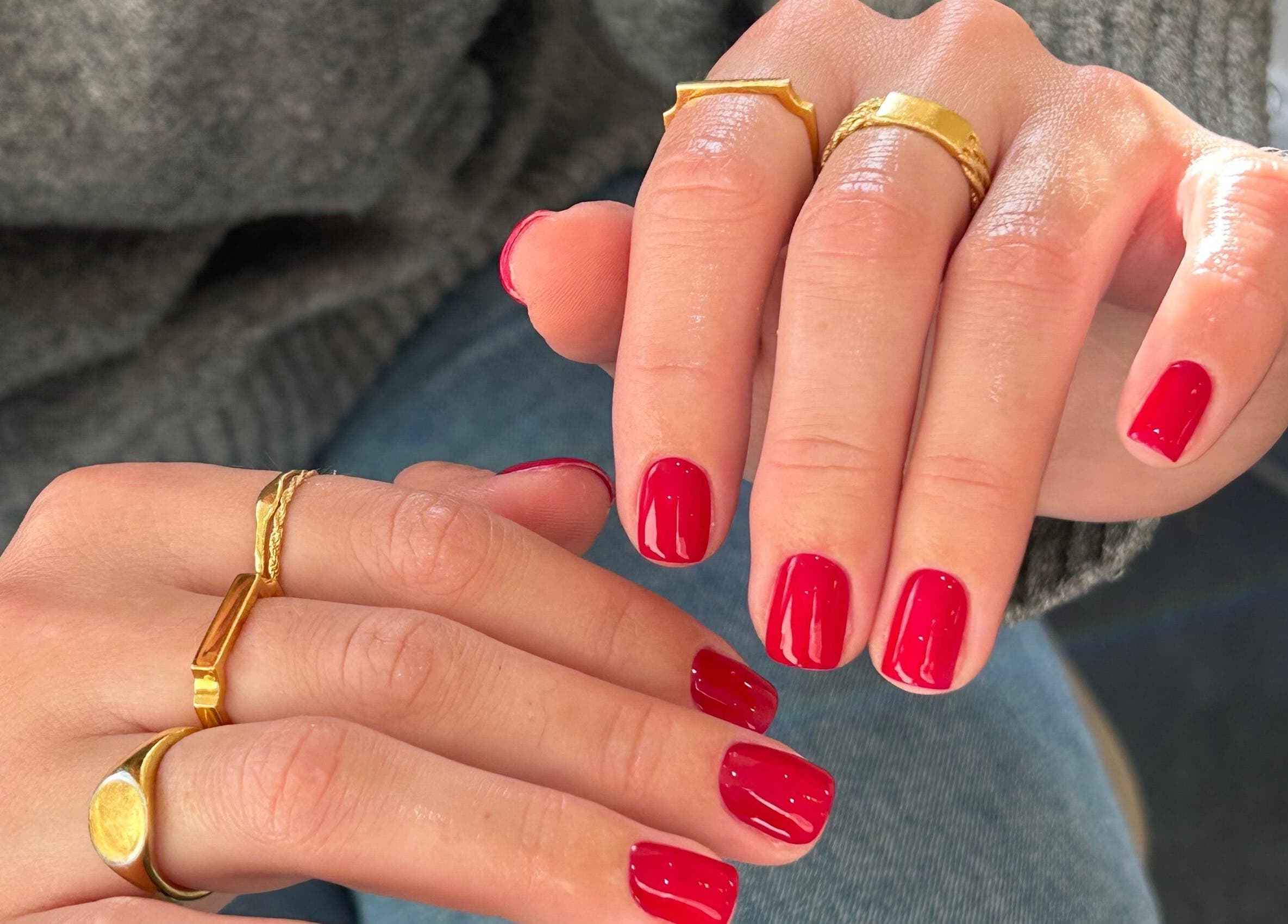 Elegant red manicure with gold rings by Jasmine Rose P, Longwell Green, England, GB.