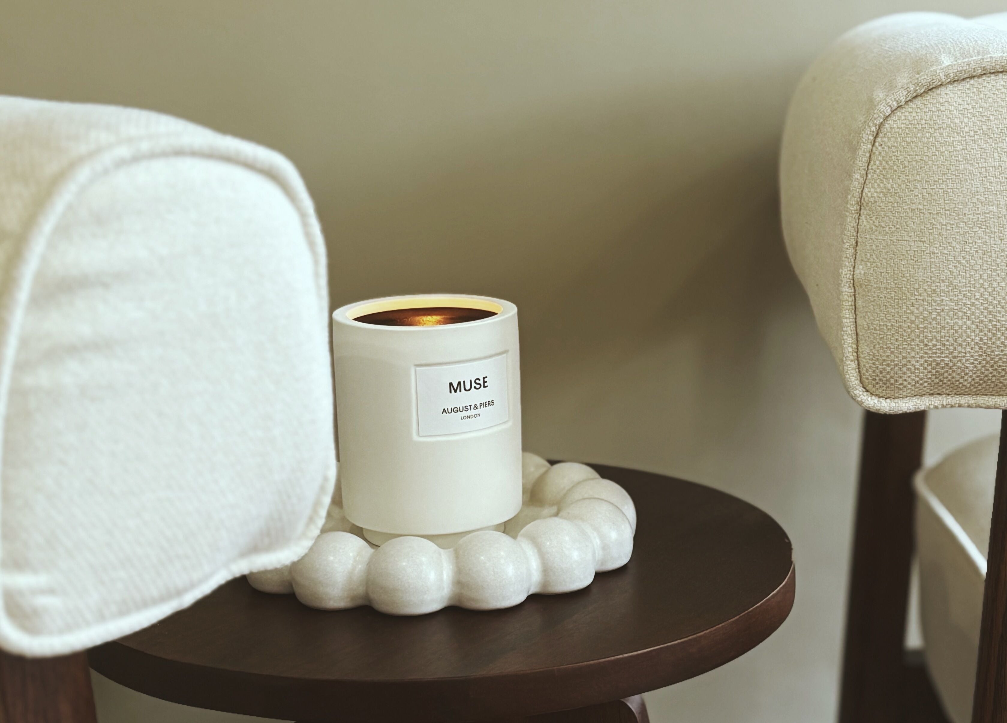 Candle on wooden table between cozy armchairs at By Jasmine Rose P, Longwell Green, England, GB.