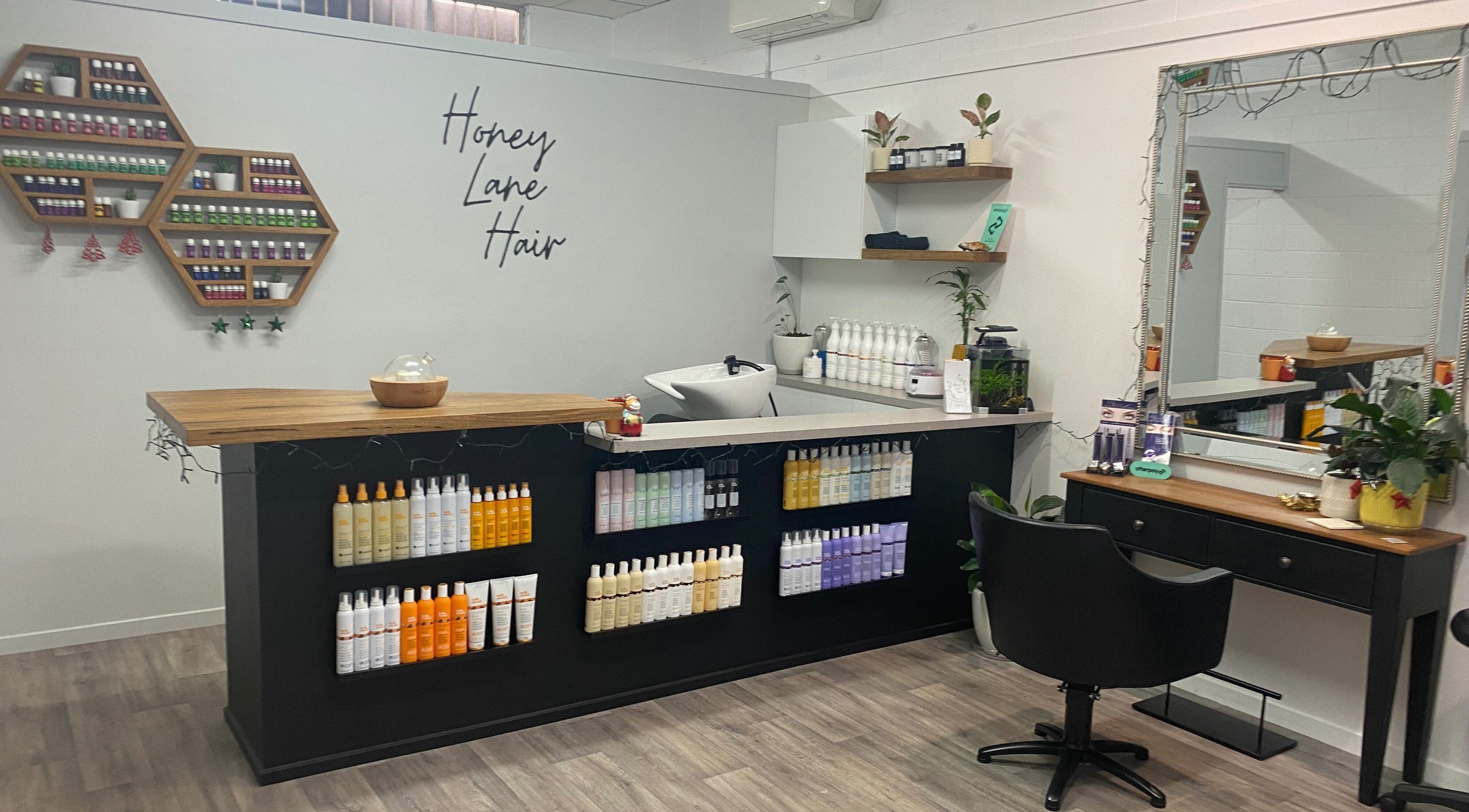 Inside Honey Lane Hair salon in Caloundra, Queensland, AU showcasing stylish and organized hair care product displays.