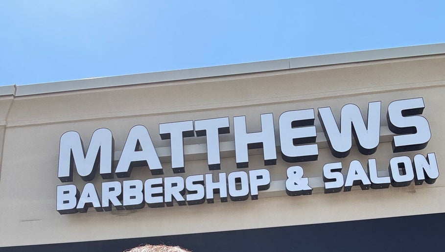 Signage of Matthews Barber Shop and Salon, Matthews, North Carolina, US, on a sunny day.