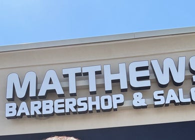 Signage of Matthews Barber Shop and Salon, Matthews, North Carolina, US, on a sunny day.