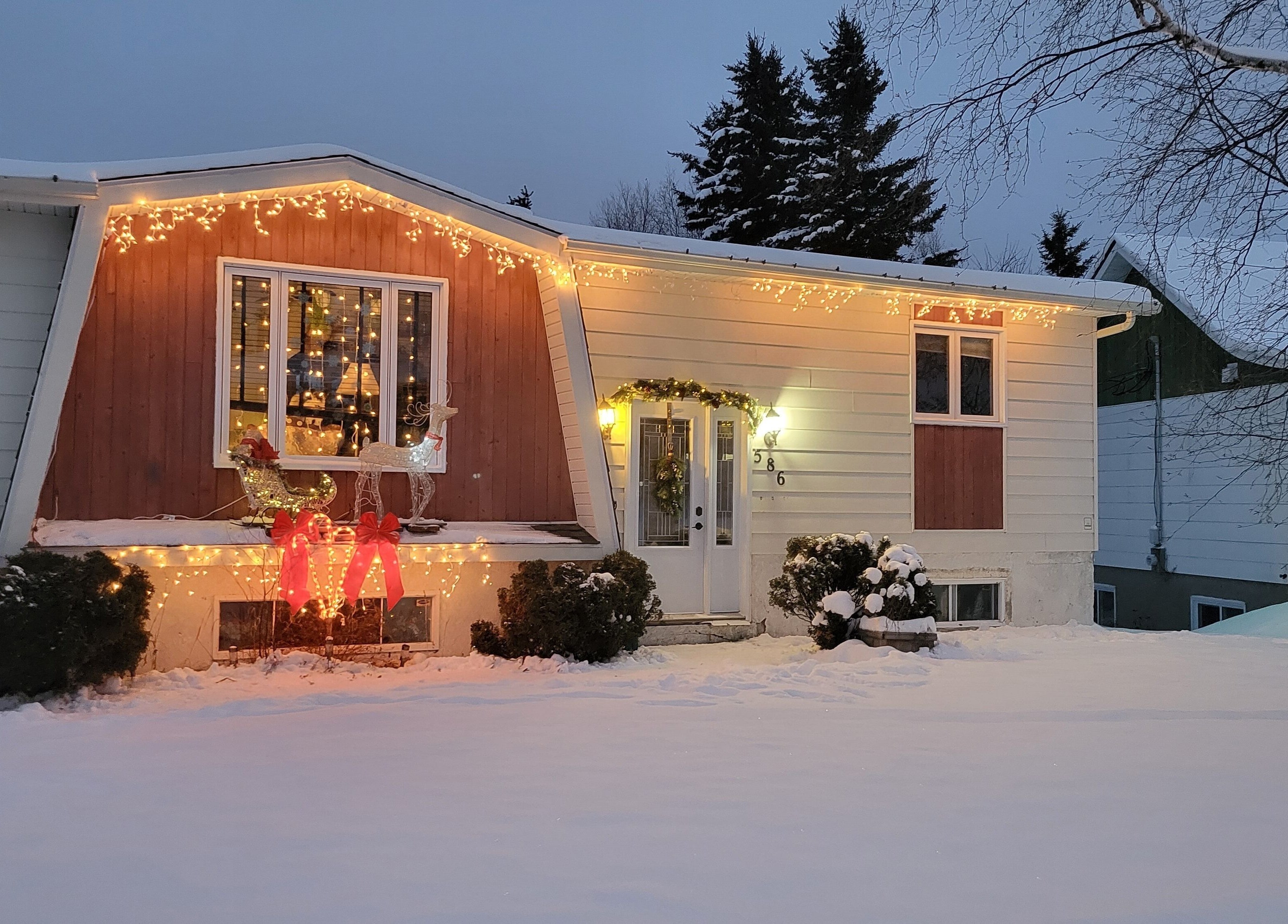 Maison illuminée pour Noël à My shop, Rouyn-Noranda, Québec, CA, créant une ambiance chaleureuse.