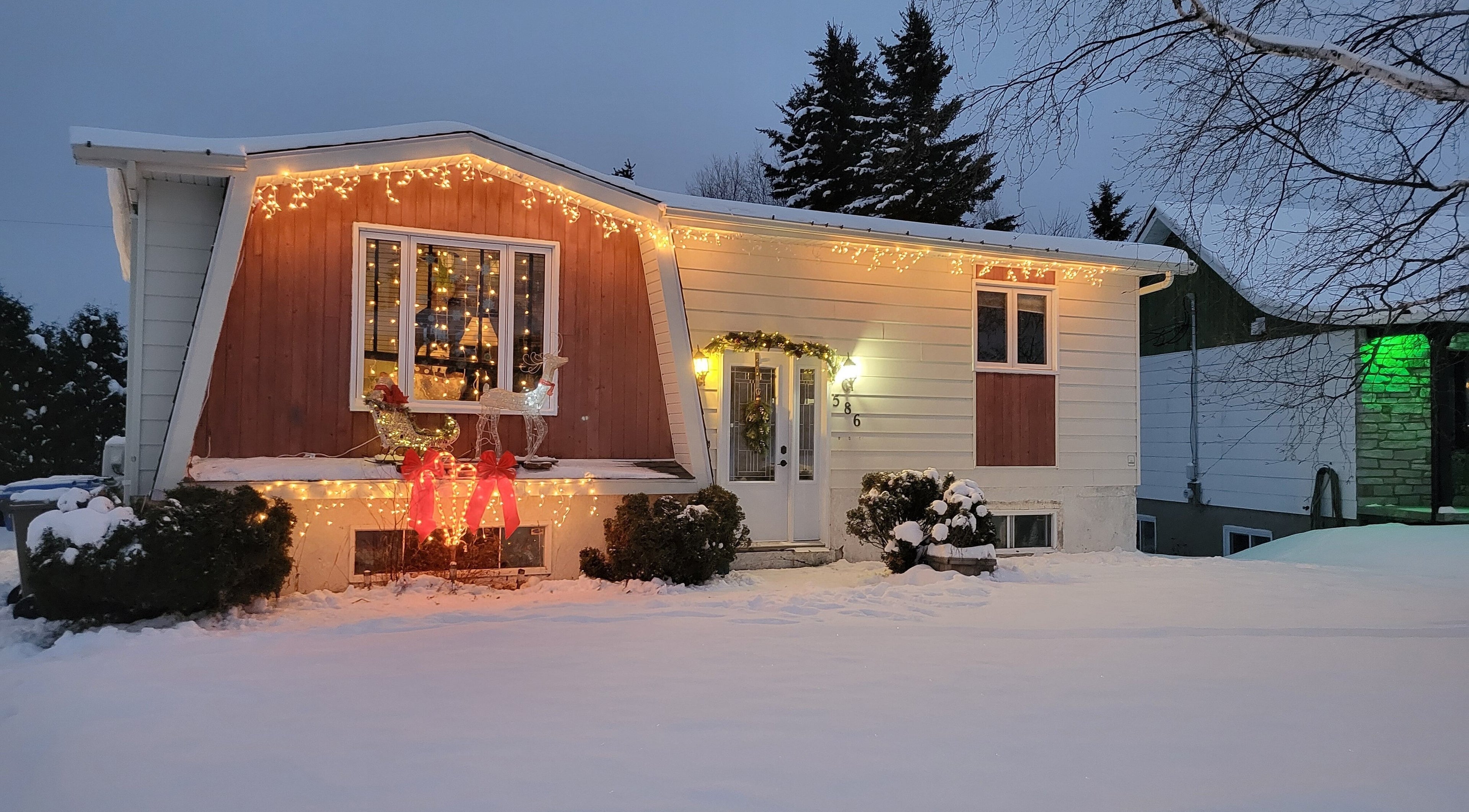 Maison illuminée pour Noël à My shop, Rouyn-Noranda, Québec, CA, créant une ambiance chaleureuse.
