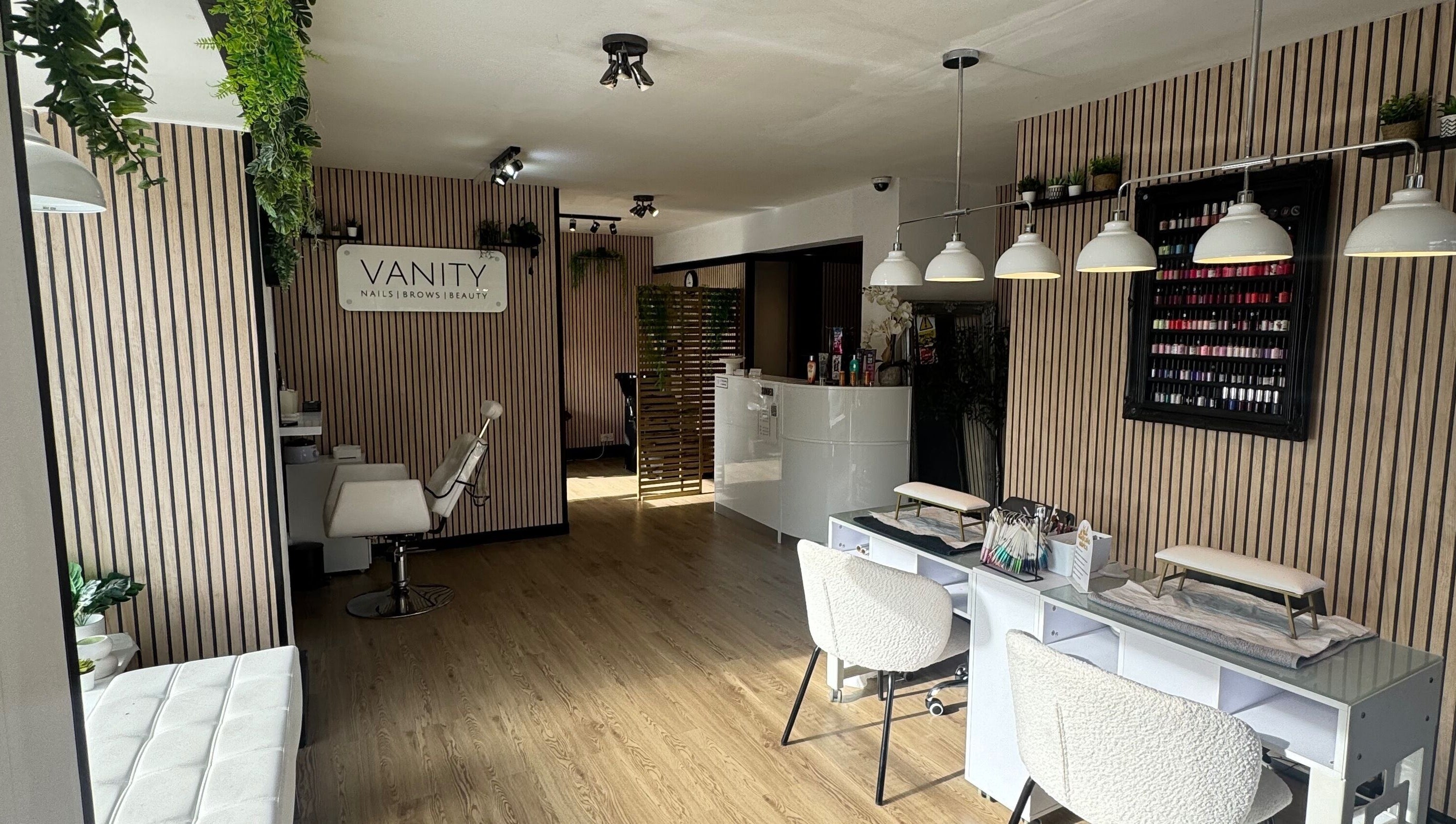 Chic interior of Vanity Beauty Naphill, High Wycombe, England, with nail stations and elegant decor.