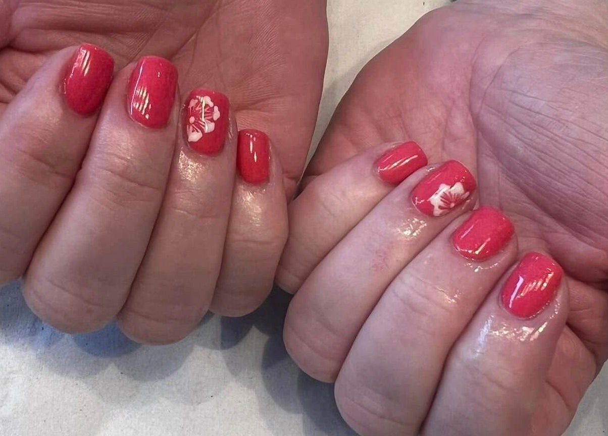 Bright coral nails with floral art at Vanity Beauty Naphill, High Wycombe, England, GB.